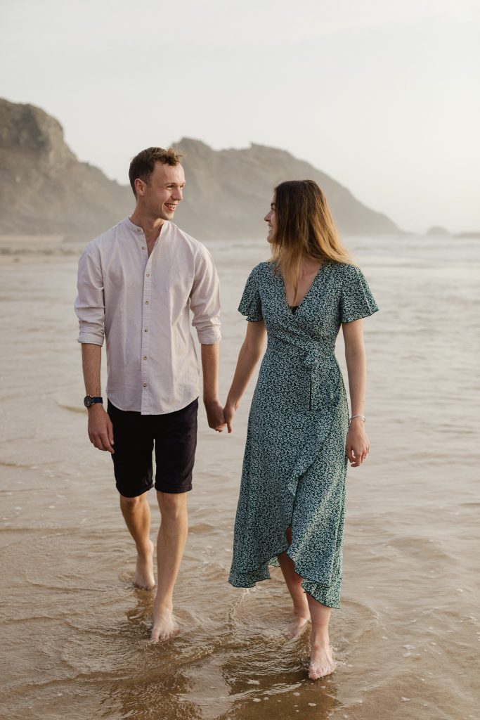 Jake and Layla celebrating getting engaged on beach in Portugal